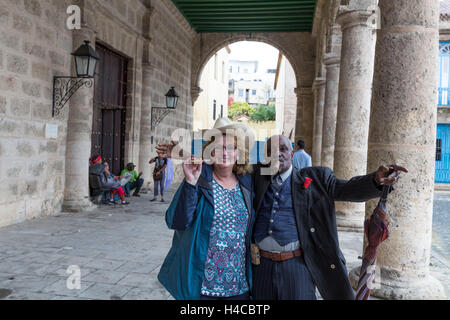 Alten kubanischen Mann mit Zigarre kann sein Zentrum mit Tourist, Plaza De La Catedral, historische Altstadt von Havanna der ein Foto aufgenommen, Habana Vieja, Kuba, die großen Antillen, Karibik, Mittelamerika, Amerika, Stockfoto