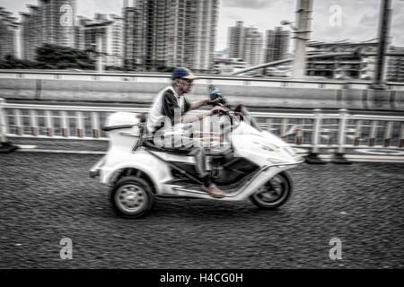 Älterer Mann auf ein Elektro-Roller Stockfoto