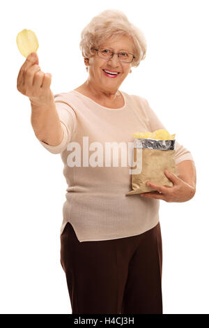 Fröhliche Reife Frau hält einen Beutel mit Pommes Frites und einem einzigen Chip isoliert auf weißem Hintergrund Stockfoto