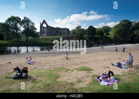 Mitglieder der Öffentlichkeit genießen Sie die Sonne in Bolton Abbey, neben der Flusses Wharfe in Wharfedale, North Yorkshire, auf 18 Septem Stockfoto