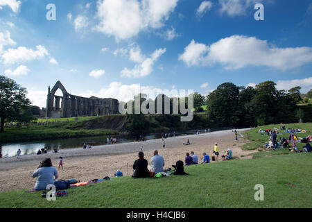 Mitglieder der Öffentlichkeit genießen Sie die Sonne in Bolton Abbey, neben der Flusses Wharfe in Wharfedale, North Yorkshire, auf 18 Septem Stockfoto