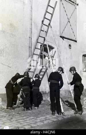 Eine Gruppe von der Kinderfeuerwehr Stellt Studienabschnitte Einer Feuerwehrübung Eine Leiter Auf, 1930er Jahre Deutschland. Eine Gruppe von junior Feuerwehr bereitet eine Leiter während der Ausbildung, Deutschland der 1930er Jahre Feuerwehrmann Stockfoto