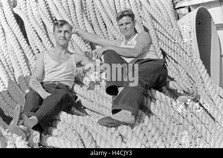 Zwei Männer des Fabrikschiffs "Jan Wellem" Bei Einer Pause Auf Tauen ein Deck, 1930er Jahre. Die Crew der Fabrikschiff "Jan Wellem", eine Pause auf Seilen an Deck, 1930er Jahre Stockfoto