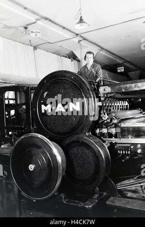 Eine Arbeiterin Kontrolliert sterben Rotationsdruckmaschine in Den Werken des Maschinenbaukonzerns MAN (Maschinenfabrik Augsburg-Nürnberg), Deutschland, 1930er Jahre. Ein Arbeiter kontrollieren die Rotationsdruckmaschine in den Werken des Maschinenbau-co Stockfoto