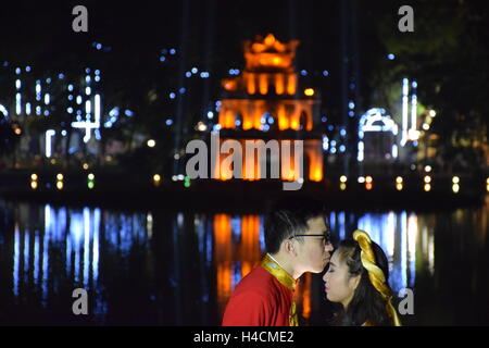 Vietnamesische paar Küssen, während Sie Fotos Hochzeit in der Nacht um den Hoan Kiem Lake in Hanoi, Vietnam Stockfoto