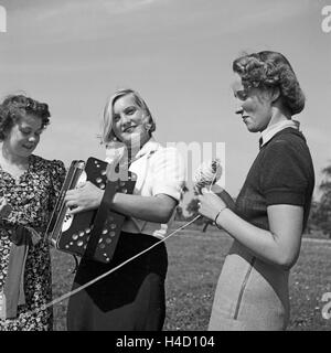 Drei Frauen Beim Musizieren Mit Einem Akkordeon, 1930er Jahre Deutschland. Drei Frauen, die Wiedergabe von Musik mit einem Akkordeon, Deutschland der 1930er Jahre. Stockfoto