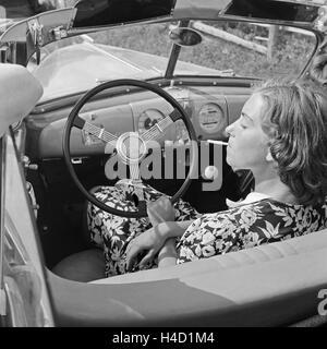 Eine Junge Frau Raucht bin Steuer Eines Opel Olympia Deuitschland 1930er Jahre.  Eine Ypung Frau Rauchen in ihr Opel Modell Olympia, Deutschland der 1930er Jahre. Stockfoto