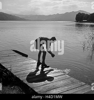 Ein Hitlerjunge Beim Händewaschen in Einem See Nahe Vom Hitlerjugend Lager Österreich 1930er Jahre. Ein Hitler-Jugend, seine Hände zu waschen, auf einem Holzsteg am See in der Nähe von Hitler Jugendcamp, Österreich der 1930er Jahre. Stockfoto