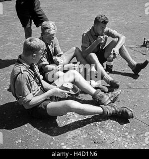 Einer der Drei Hitlerjungen in der Mittagspause Zusammen Beim Feldmäßigen Essen, 1930er Jahre Österreich. Drei Hitler Jugendlichen zusammen sitzen und mit Mittagspause, Österreich der 1930er Jahre. Stockfoto