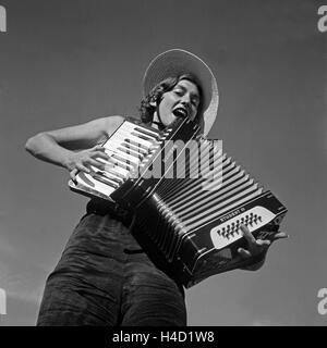 Eine Junge Frau Spielt Im Urlaub Auf Einem Akkordeon, Österreich, 1930er Jahre. Eine junge Frau spielt Akkordeon, Österreich, 1930er Jahre. Stockfoto