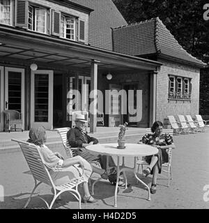 Zwei Frauen Und Ein Mann einer Auf Einer Terrasse ein Einem Gartentisch, 1930er Jahre Deutschland. Zwei Frauen und ein Mann sitzt auf einer Terrasse an einem Gartentisch, Deutschland der 1930er Jahre. Stockfoto