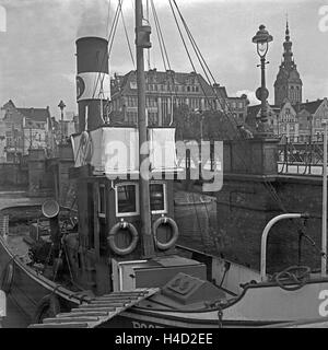 Boot Im Hafen von Elbing Mit der Liegebrücke Und der Nikolaikirche Im Hintergrund, Masurem, Ostpreußen, Deutschland 1930er Jahre. Boot im Hafen von Elbing mit Liegebruecke Bridge und St. Nikolaus-Kirche im Hintergrund, Masuren, Ostpreußen, Deutschland der 1930er Jahre. Stockfoto