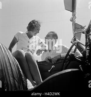 Ein Junger Mann Und Eine Junge Frau ein Einem Ford V8 Cabrio, Deutschland 1930er Jahre. Ein junger Mann und eine junge Frau mit einem Ford V8 Cabrio, Deutschland der 1930er Jahre. Stockfoto