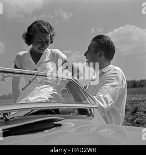 Ein Junger Mann Und Eine Junge Frau ein Einem Ford V8 Cabrio, Deutschland 1930er Jahre. Ein junger Mann und eine junge Frau mit einem Ford V8 Cabrio, Deutschland der 1930er Jahre. Stockfoto