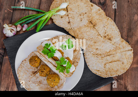 Kichererbse Falafel mit Minze-Dressing und libanesische Brot, frische Kräuter obenauf Stockfoto