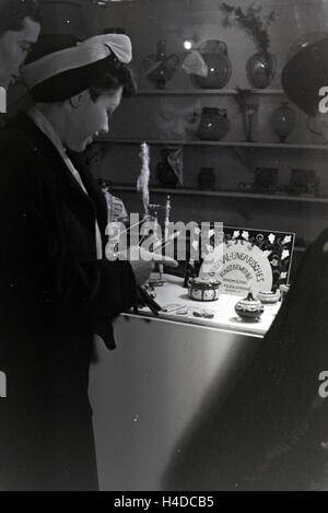 Besucher der Wiener Modewoche, Im Haus der Mode "Palais Lobkowitz', Vor Einem Schaukasten Mit Ungarischem Kunsthandwerk; 1940er Jahre Deutschland. Besucher der Vienna Fashionweek, in das Haus der Mode 'Palais Lobkowitz', vor einer Vitrine Stockfoto