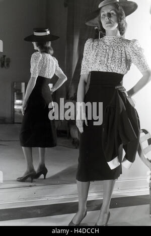 Ein Modell Bei der Anprobe Eines Kleides der Berliner Modeschöpfer Nina Carell Und Heinz Schulze-Bibernell, Deutschland ca. 1939. Ein Modell, das versucht einer Kleid von Mode-Designerin Nina Carell und Heinz Schulze-Bibernell, Deutschland ca. 1939. Stockfoto