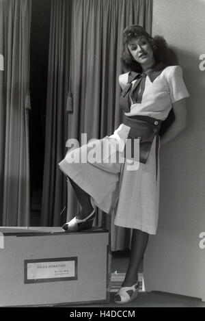 Ein Modell Bei der Anprobe Eines Kleides der Berliner Modeschöpferin Hilda Romatzki, Deutschland ca. 1939. Ein Modell, das versucht einer Kleid von Mode-Designer Hilda Romatzki, Deutschland ca. 1939. Stockfoto