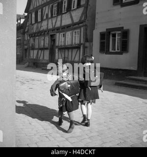 Zwei Kleine Mädchen Auf Dem Weg Zur Schule, 1930er Jahre Deutschland. Zwei kleine Mädchen auf ihrem Weg zur Schule, Deutschland der 1930er Jahre. Stockfoto