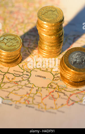 Stapel von 1 Pfund-Münzen um Fahrplan zeigt London Vereinigtes Königreich Stockfoto