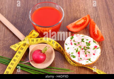 Vegetarisches Sandwich mit Käse und Gemüse, Glas Tomatensaft und Maßband, abnehmen frisch Stockfoto