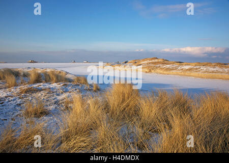 Verschneite Dünen und Strand Stück Peter-Ording in einem sonnigen Winternachmittag Stockfoto