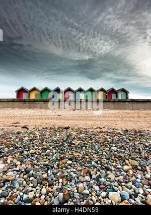 Eine Reihe von bunten Strandhäuschen an einem Sommertag am Strand, jede Farbe des Regenbogens in Blyth, Northumberland Stockfoto