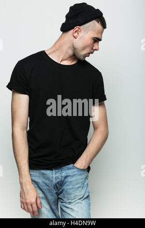 Studioportrait Mann posiert vor grauem Hintergrund. Stockfoto