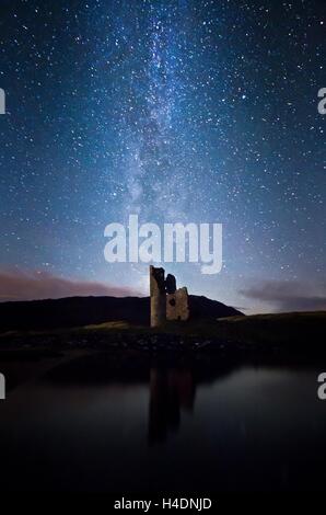 Die Milchstraße erhebt sich über den Ruinen von Ardvreck Castle am Ufer des Loch Assynt in den Highlands von Schottland Stockfoto