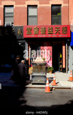 Buddhistische Mönche verbrennen Joss Papiergeld für starb nach einer Zeremonie außerhalb eines Tempels in New York Chinatown.New York City, USA Stockfoto