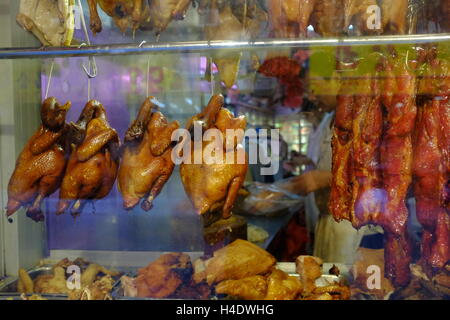 Kantonesischen Stil gebratene Enten, Hühner- und Schweinefleisch hängenden innerhalb des Fensters von einem Chinesischen Restaurant in Chinatown. Manhattan, New York, USA Stockfoto