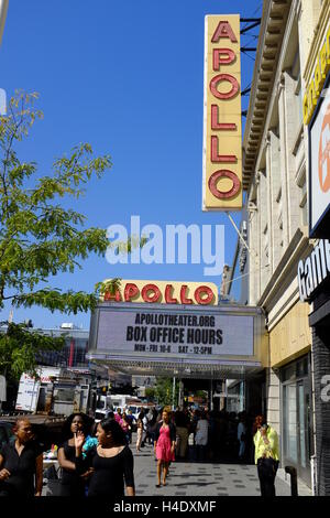 Fußgänger an der 125th Street mit Zeichen des Apollo Theater am Eingang des Theaterin Hintergrund. Harlem, New York City, USA Stockfoto