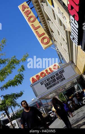 Fußgänger an der 125th Street mit Zeichen des Apollo Theater am Eingang des Theaterin Hintergrund. Harlem, New York City, USA Stockfoto