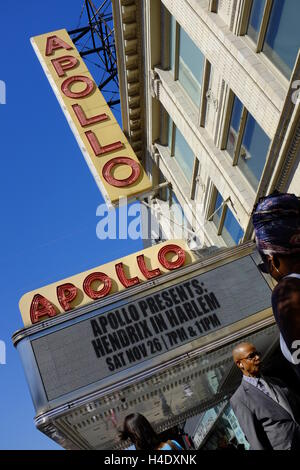 Fußgänger an der 125th Street mit Zeichen des Apollo Theater am Eingang des Theaterin Hintergrund. Harlem, New York City, USA Stockfoto