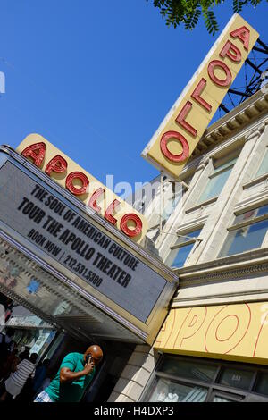 Fußgänger an der 125th Street mit Zeichen des Apollo Theater am Eingang des Theaterin Hintergrund. Harlem, New York City, USA Stockfoto