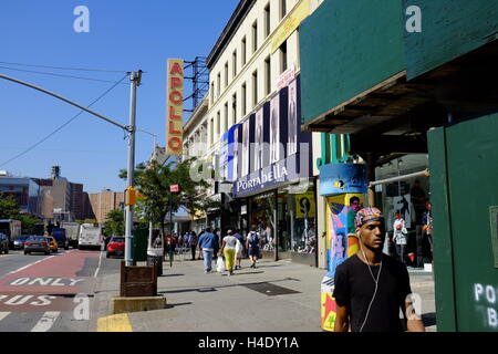 Fußgänger an der 125th Street mit dem Zeichen des Apollo Theater im Hintergrund. Harlem, New York City, USA Stockfoto