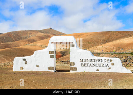 Typische Gemeinde melden (weißes Bogens Tor) in der Nähe von Betancuria Dorf mit einsamen Berglandschaft im Hintergrund, Fuerteventura, Kanarische Inseln, Spanien Stockfoto