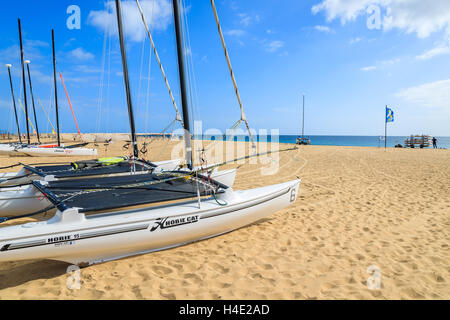 MORRO JABLE, FUERTEVENTURA - 7. Februar 2014: Katamaran-Boote am Strand in Morro Jable. Dies ist ein beliebter Ferienort auf der Insel Fuerteventura. Stockfoto