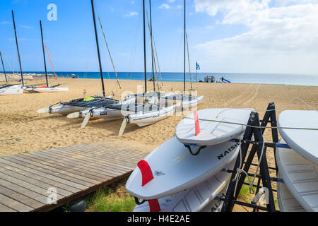 MORRO JABLE, FUERTEVENTURA - 7. Februar 2014: Surfbretter und Katamaran-Boote am Strand in Morro Jable. Dies ist ein beliebter Ferienort auf der Insel Fuerteventura. Stockfoto