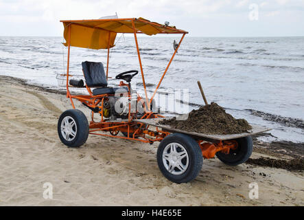 Das Auto für die Garbagecollection vom Strand entfernt. Reinigung am Strand, sauberer Strand vor Schlamm und Abfall. Stockfoto