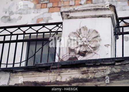 Alten verlassenen Haus Fragment mit geschälten Farbe auf die Wand und Eisen Guss Fincing, Blume Formen voller Risse Stockfoto