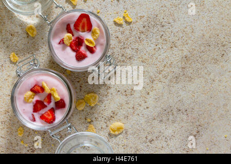 Hausgemachter Joghurt mit Cornflakes und Beeren, gesunde Essen Joghurt, Ansicht von oben. Stockfoto