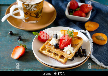 Traditionelle belgische Waffeln mit Sahne Schlagsahne Sahne und frische Beeren auf Vintage-Hintergrund, zum Frühstück serviert. Stockfoto