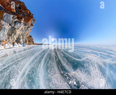 Im Weitwinkel Schamane Rock oder Kap Burchan auf Olchon im Winter, umgeben von blauen Eis des Baikalsees mit Rissen. Stockfoto