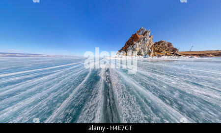 Im Weitwinkel Schamane Rock oder Kap Burchan auf Olchon im Winter, umgeben von blauen Eis des Baikalsees mit Rissen. Stockfoto