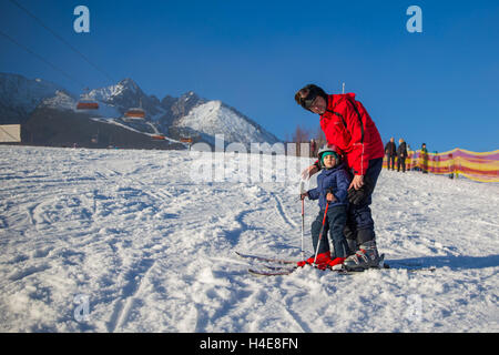 Glückliche kleine Junge lernen Skifahren mit seinem Vater im Winterurlaub in der hohen Tatra, Slowakei Stockfoto