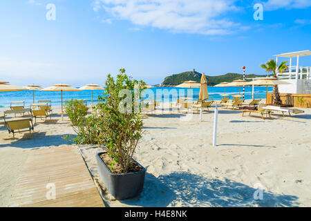 Liegestühle mit Sonnenschirmen und Rettungsschwimmer Turm am Strand von Porto Giunco, Insel Sardinien, Italien Stockfoto