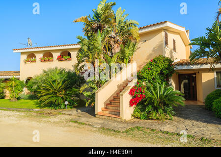 PORTO GIUNCO, Sardinien - 24. Mai 2014: Ferien-Apartment-Hotel in einem tropischen Garten, Insel Sardinien, Italien. Südlichen Teil der Insel ist für Strandurlaub unter den Europäern beliebt. Stockfoto