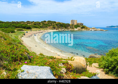 Schöne Bucht mit Strand und Azure Meer mit Schloss im Hintergrund in der Nähe von Porto Giunco Hafen, Insel Sardinien, Italien Stockfoto