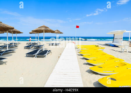 PORTO GIUNCO Strand, Sardinien - 25. Mai 2014: gelbe Kajaks und Sonnenschirme mit Sonnenliegen am Strand von Porto Giunco, Insel Sardinien, Italien. Süden der Insel hat die schönsten Strände in Europa. Stockfoto